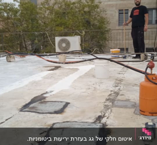 אדם על גג עם ציוד לאיטום וזפת